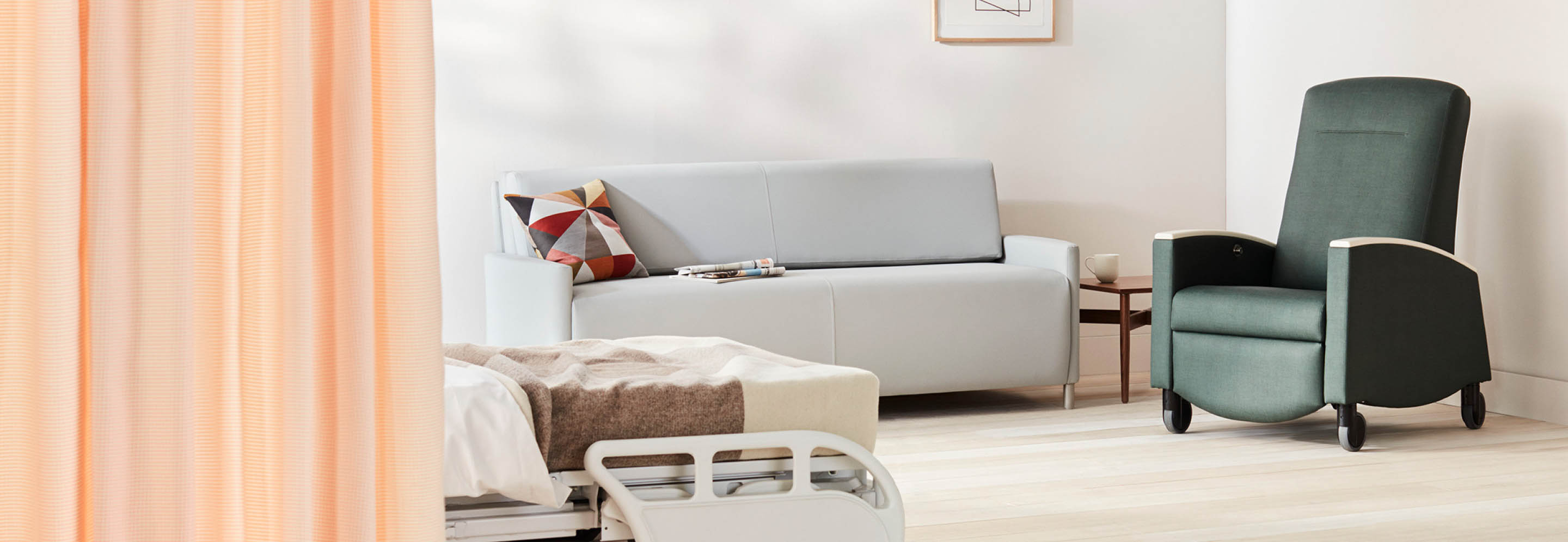 Patient room with a light gray Pamona Flop Sofa and a dark green Sahara recliner.