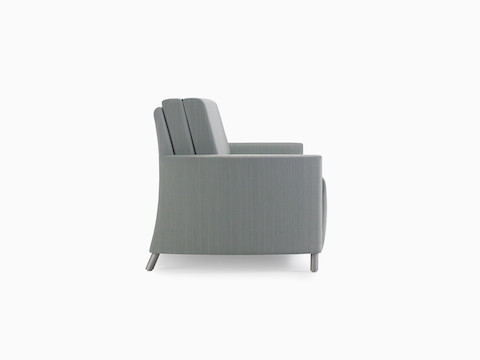 A side view of a Nemschoff Pamona Flop Sofa in a gray textile with metal legs.