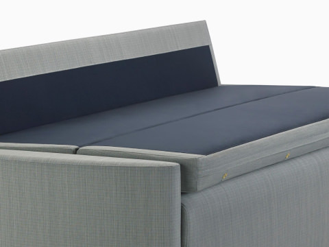 Cropped view of Nemschoff Pamona Flop Sofa in a gray upholstery with the sleep surface open.