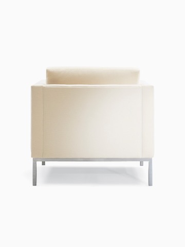 A Riva Armchair in light textile with brushed metal legs, viewed from the back.