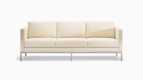 A Riva lounge sofa in a light-colored textile with brushed metal legs.