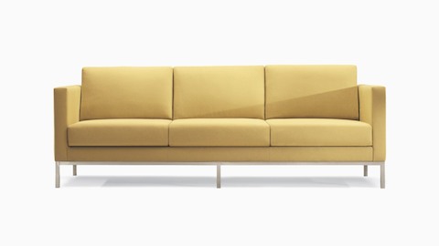 A Riva Sofa in a yellow textile with brushed metal legs.