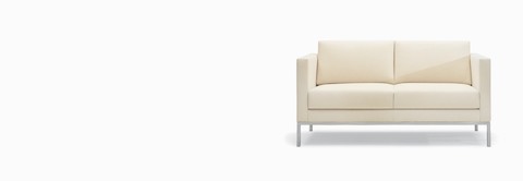 A Riva Sofa in a light-colored textile with brushed metal legs.