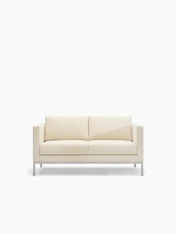 A Riva lounge settee in a light-colored textile with brushed metal legs.