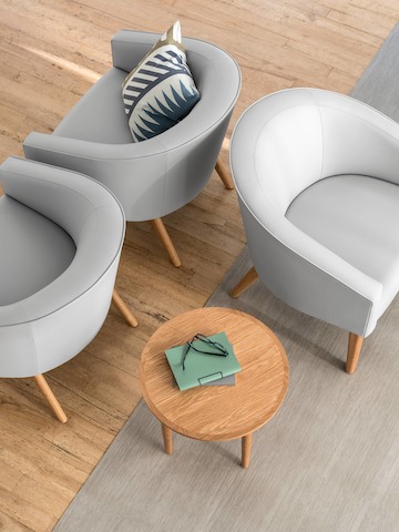 The Nemschoff Sophora Lounge Chairs in a light gray upholstery, positioned back to back with a Nemschoff Hemlock Side Table next to one chair.