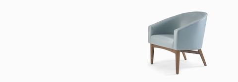 A Sophora Lounge Chair in light blue textile with walnut legs and base.