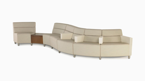 A low-back Nemschoff Steps Lounge System in a curved configuration in a light-colored textile.