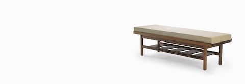 A Tamarack Table and Bench in walnut with a light-colored cushion. A Tamarack Table and Bench in walnut with a light-colored cushion.