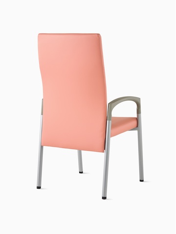 Three-quarter, back view of a high-back Valor Patient Chair in a salmon pink upholstery and silver frame with pewter armcaps.