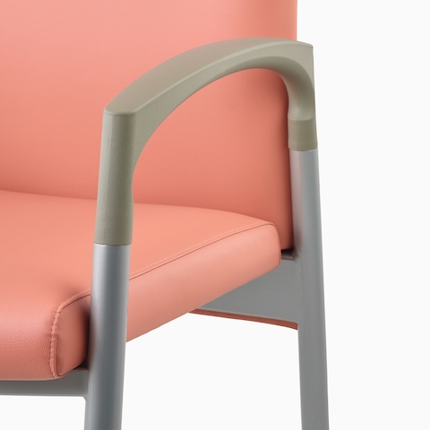 Detail of a silver frame and pewter armcap on a Valor Patient Chair upholstered in salmon.