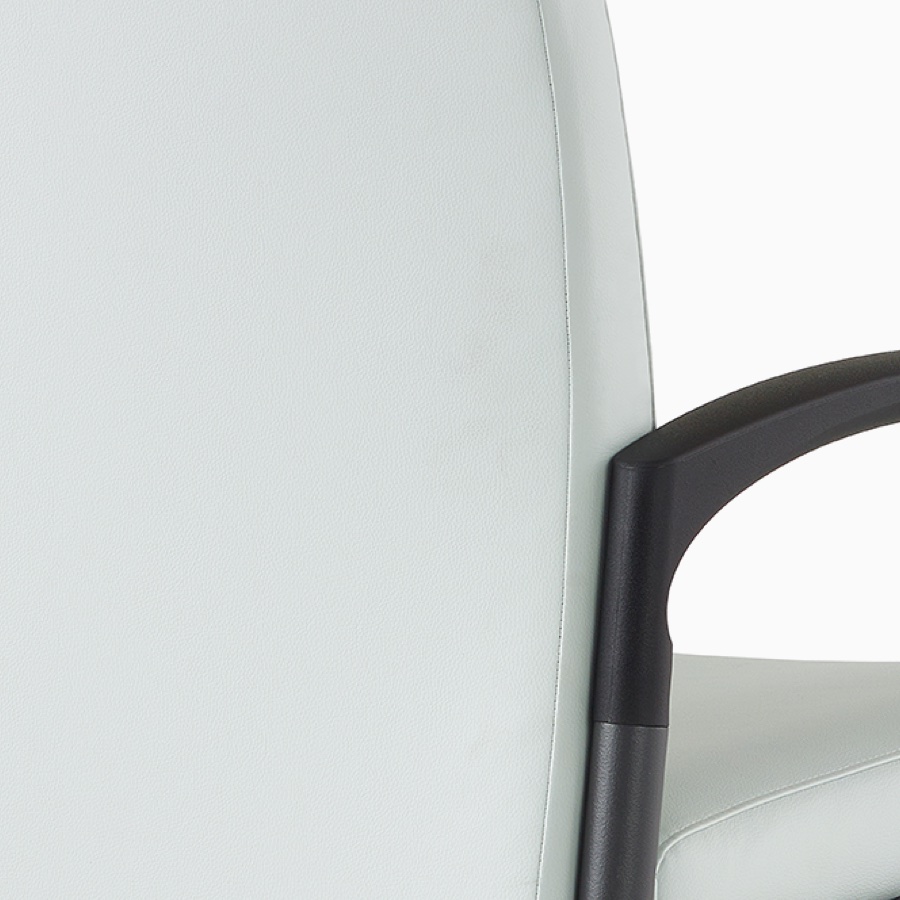 Detail of the back of an upholstered Valor chair and contoured arm and armcap.