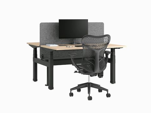 Zwei Rücken an Rücken angeordnete Nevi Link Sitz-Steh-Schreibtische in Schwarz mit hellen Holzarbeitsplatten und Textil-Trennwand, Monitor und Mirra 2 Stuhl.