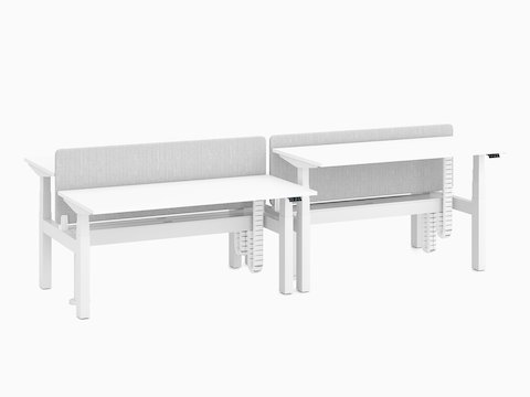 Nevi Link Sit-Stand back-to-back four-desk configuration in white with grey fabric screens and two desks raised to standing height.