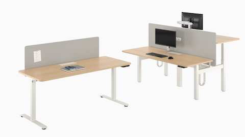 A freestanding Nevi Sit-to-Stand Desk next to a back-to-back two-desk configuration.