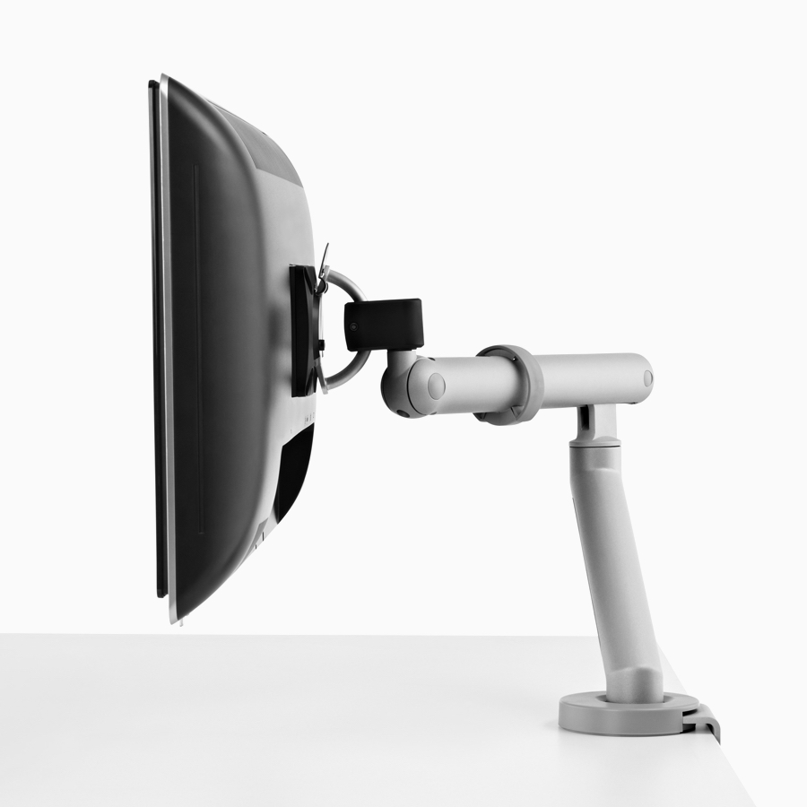 A computer monitor supported by a silver Flo Monitor Arm.