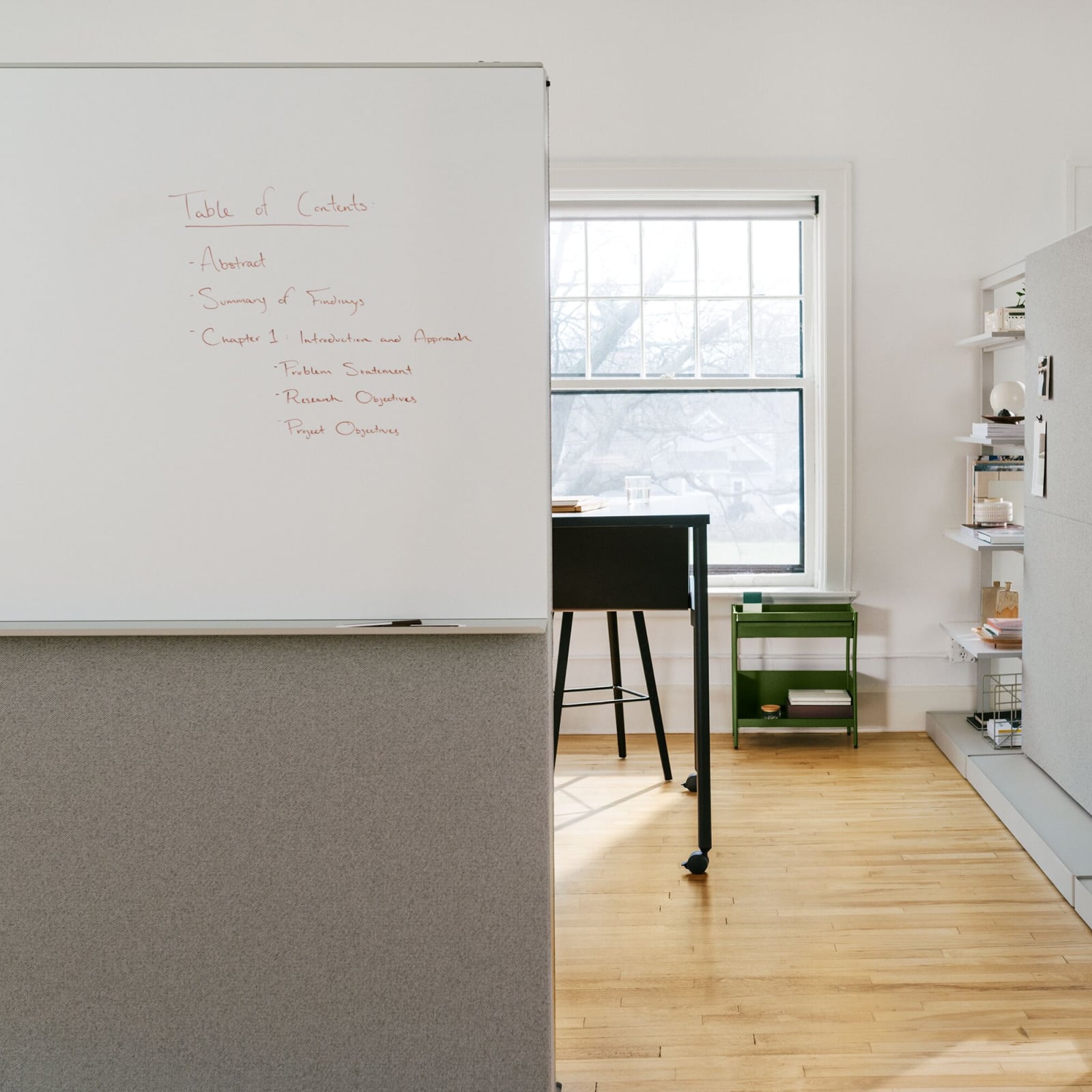 Grey OE1 Agile Walls with markerboards, shelves, and tackable surfaces with black OE1 Communal Table and green OE1 Storage Trolley in the background.