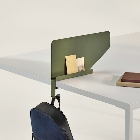 Una Pantalla límite OE1 en verde con una cartera azul colgando del gancho para bolsos y carteras.