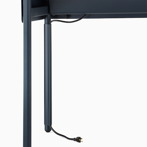 Close up image of a blue OE1 Communal Table with power cable routing from the surface to the floor through a vertical cable manager.