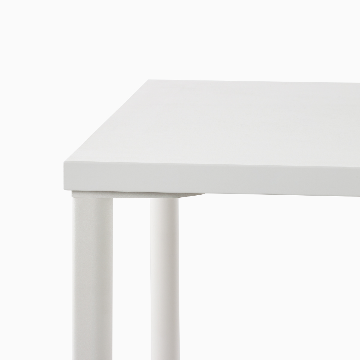 Primer plano del detalle de la pata de una mesa rectangular OE1 con superficie en blanco y patas en blanco.