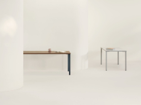 An OE1 Rectangular Table with dark brown surface and blue legs, with an OE1 Rectangular Table with white surface and grey legs in the background. An OE1 Rectangular Table with dark brown surface and blue legs, with an OE1 Rectangular Table with white surface and grey legs in the background.