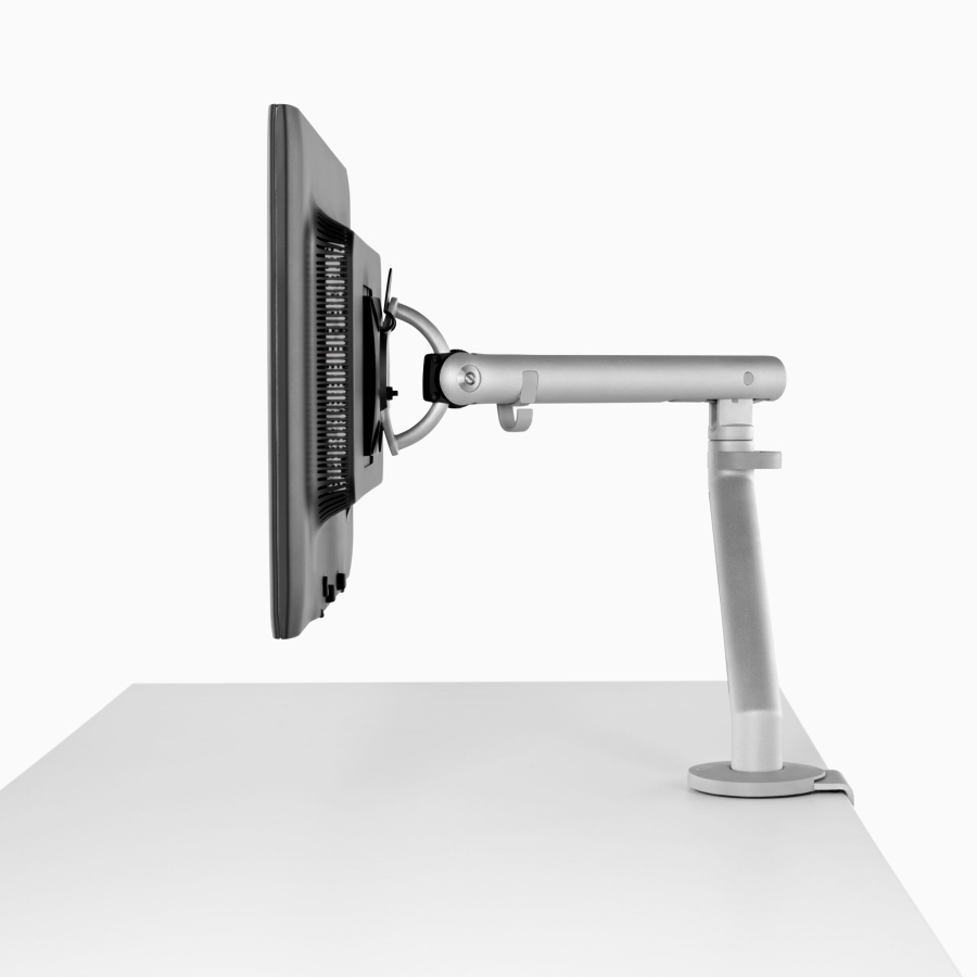 A computer monitor supported by a silver Flo Monitor Arm.