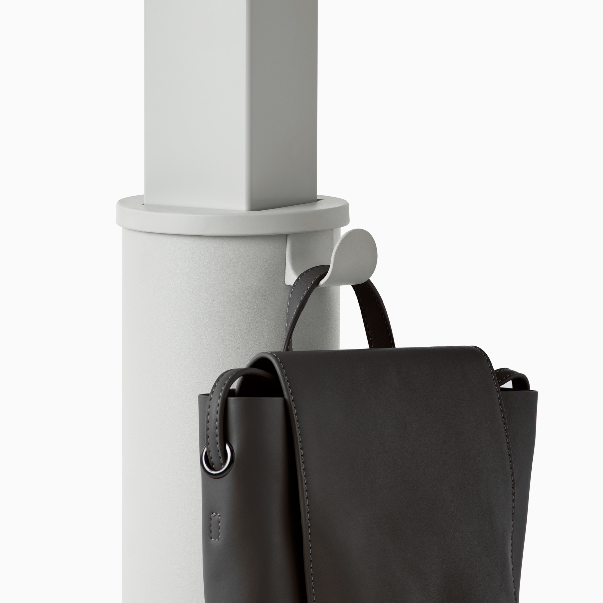 Detail van een grijze OE1 Zit-sta tafelkolom met een zwarte tas die aan de tassenhaak hangt.