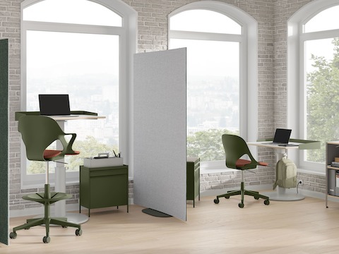 Bright office with green and grey OE1 Curved Screens, green OE1 Storage Trolleys, green Zeph Chair and OE1 Sit-to-Stand Tables.