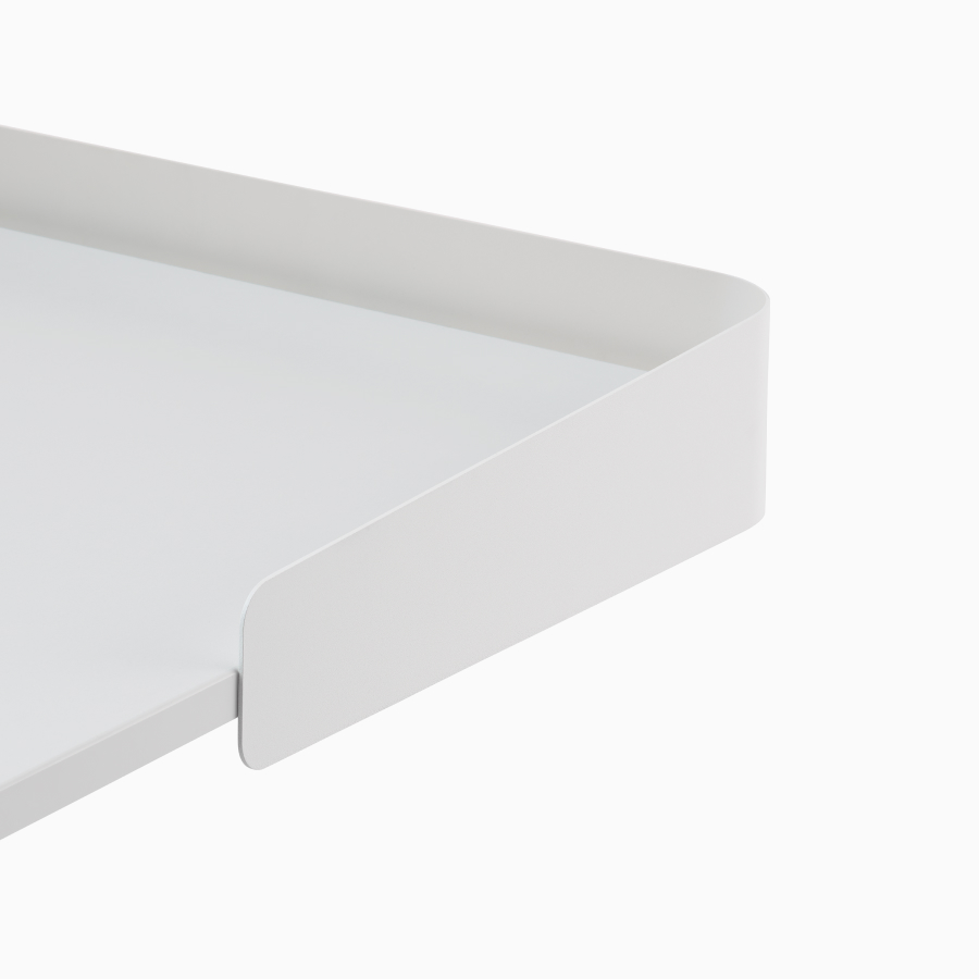 Detalle de la superficie de una mesa Sit-to-Stand OE1 blanca con pantalla envolvente gris, vista desde un ángulo frontal.