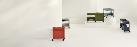 Dark blue, light blue, red and green OE1 Storage Trolleys in various configurations, including casters and glides.