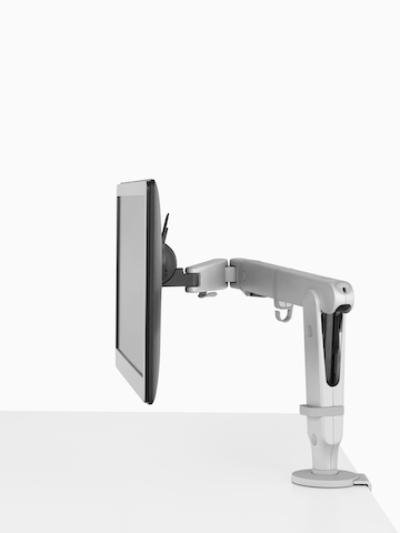 An adjustable Ollin Monitor Arm attached to a work surface.