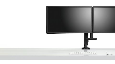 Vista de frente de dos monitores sujetados a un brazo articulado Ollin en negro en una configuración dual, con la manivela de barra dual opcional agregada para mayor facilidad de ajuste en el posicionamiento de la pantalla.