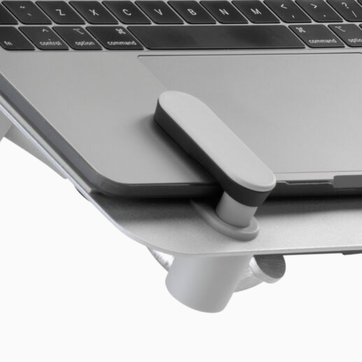 A close-up view showing a front corner of an open laptop supported by an Ollin Laptop Mount