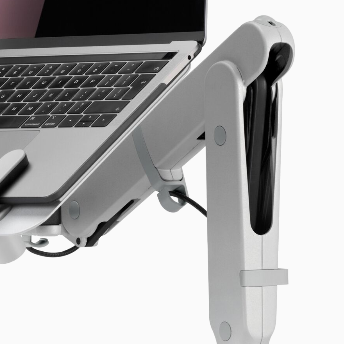 A close-up view showing a front section of an open laptop raised to eye level and supported by Ollin Laptop Mount and Ollin Monitor Arms