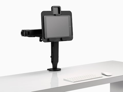 Un tablet sorretto da un supporto per portatili e tablet Ollin collegato a un braccio porta monitor Ollin nero.