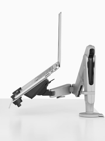 An adjustable Ollin Monitor Arm supports an open laptop computer. An adjustable Ollin Monitor Arm supports an open laptop computer.