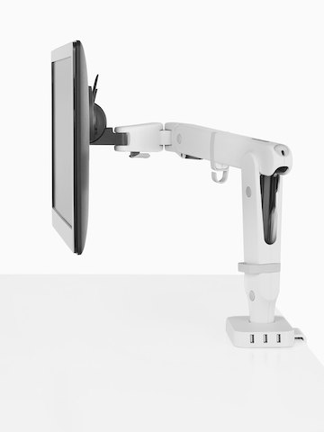 Profile view of a monitor supported by an Ollin Monitor Arm that’s connected to  a Flo Power Hub with three USB ports.