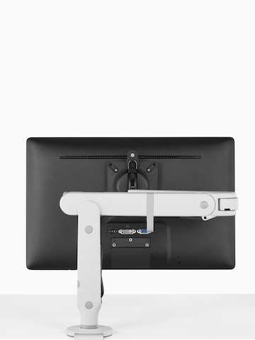 An adjustable Ollin Monitor Arm attached to a work surface. Select to go to the Ollin Monitor Arms product page.