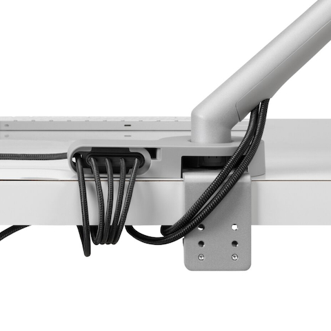 Back view of power and data cables routed from the connected monitor arm and through the Ondo Connectivity Module and Loop Micro Mount under a desk.