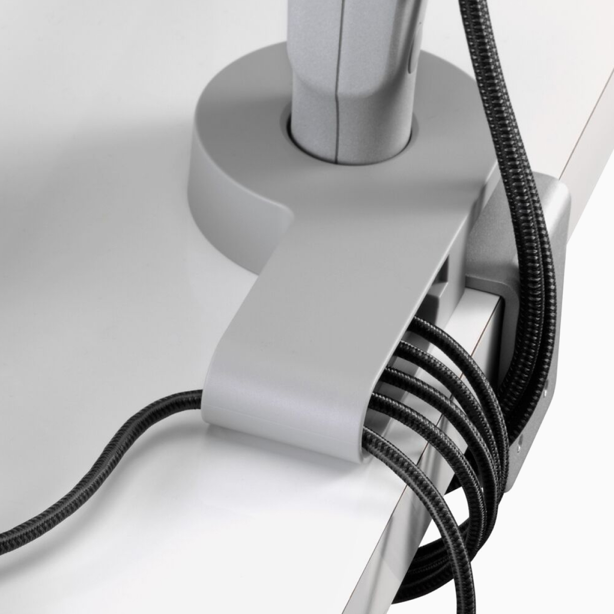 Angled view of power and data cables routed through an Ondo Connectivity Module and under a desk.