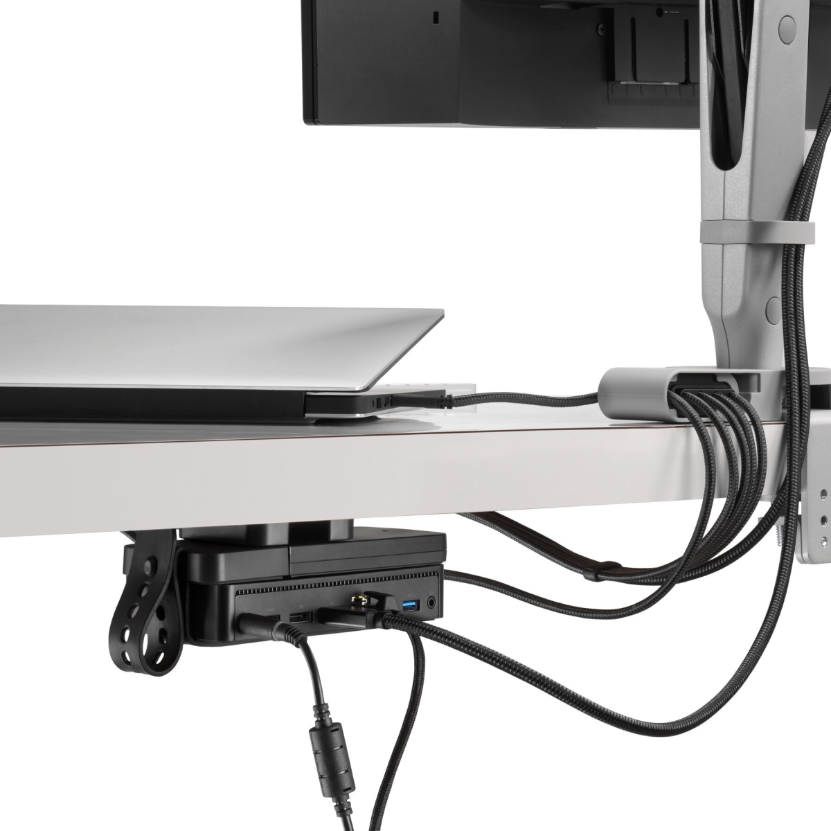 Back angled view of a monitor screen with cables routed from the connected monitor arm and through an Ondo Connectivity Module to a laptop and Loop Micro Mount under a desk.