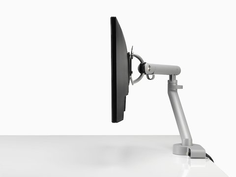 Profilansicht eines Bildschirms an einem Flo Monitorarm, integriert mit einem Ondo Verbindungsmodul auf einem Schreibtisch.