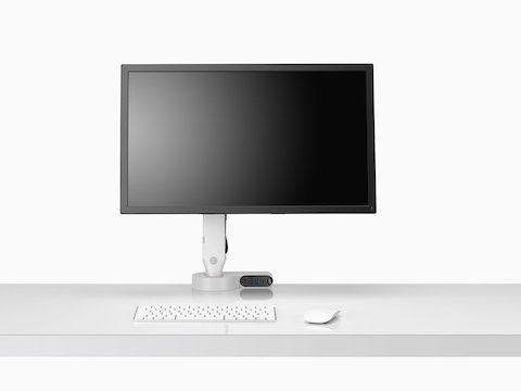 Vooraanzicht van een scherm bevestigd aan een Olin-monitorarm ingebouwd met een Ondo-connectiviteitsmodule op een bureau.