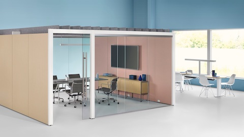 Sala de reuniões Overlay fechada com duas paredes de vidro e duas paredes laminadas com mesa de conferência e quatro cadeiras.