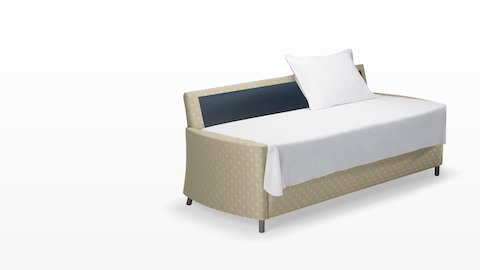 A beige-patterned Pamona Flop Sofa converted into a sleep surface with a sheet and pillow. A beige-patterned Pamona Flop Sofa converted into a sleep surface with a sheet and pillow.
