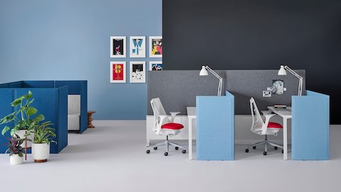 Light blue fabric Pari freestanding privacy screens attached to the front and to the side of two desks connected to Canvas Dock.