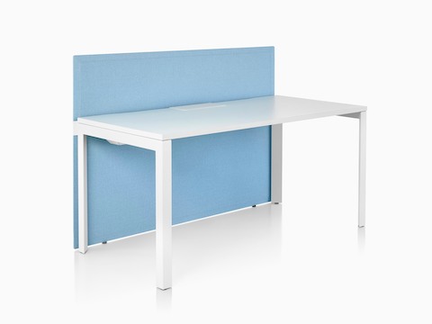 A light blue fabric Pari freestanding privacy screen attached to the front of a white Layout Studio desk.