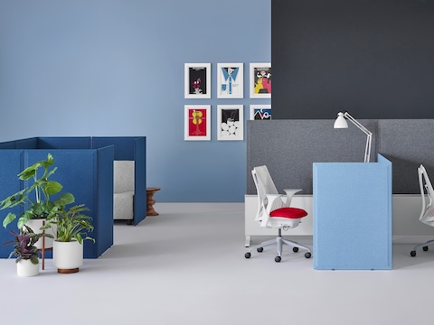 Light blue fabric Pari freestanding privacy screens attached to the front and side of two desks connected to Canvas Dock.