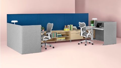 Gray freestanding Pari Screens combine with blue surface-attached Pari Screens to create boundaries for adjacent workstations.