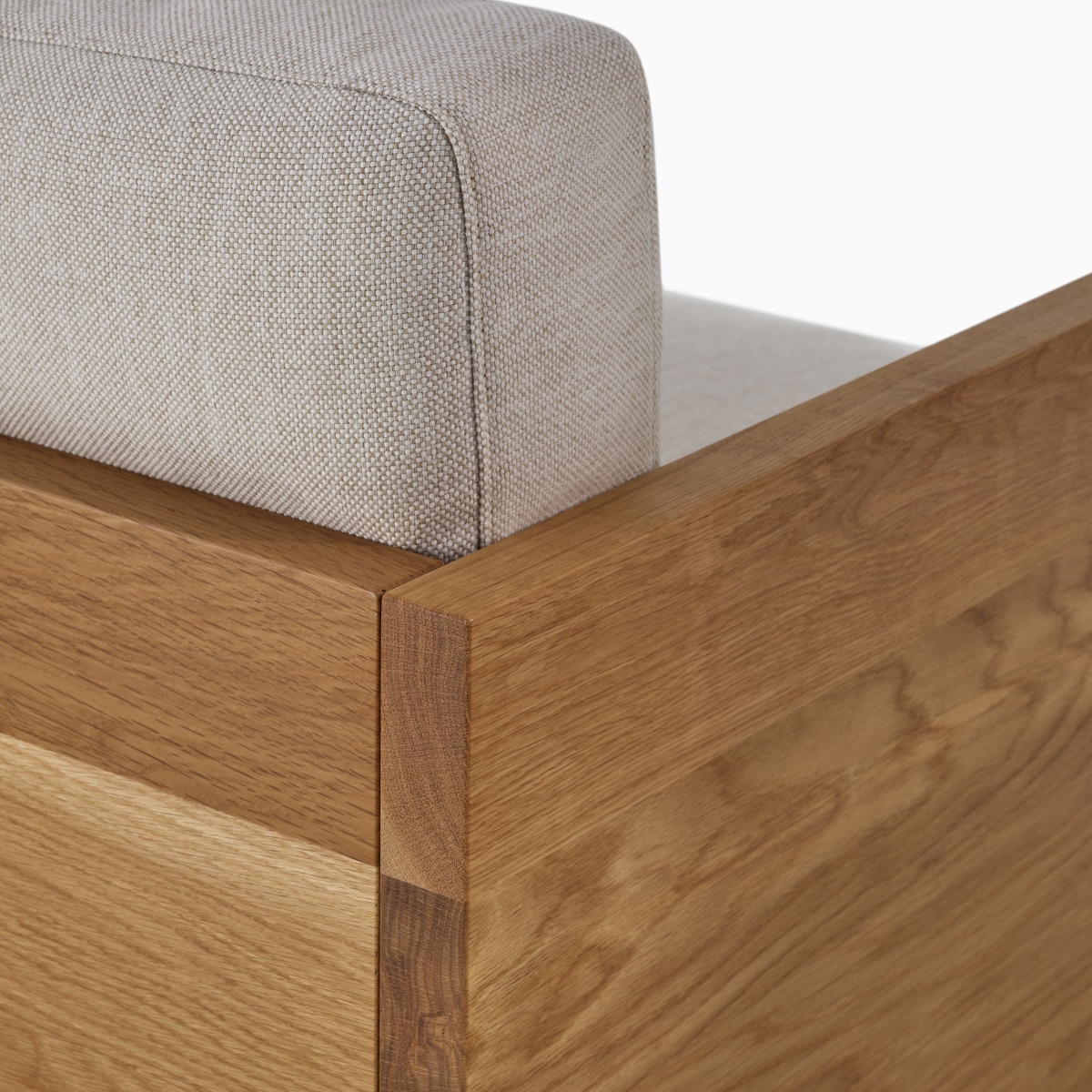 A detail view of the Pawson Drift Sofa Groups back corned with solid wood oak and grey cushion.