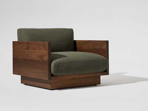 Angle view of the Pawson Drift Lounge Chair with walnut frame and green cushions.